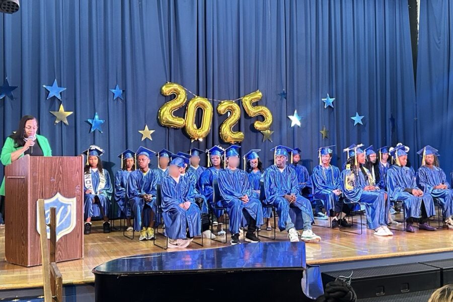 Westminster Community Charter School 8th grade graduation with students on stage in blue robes