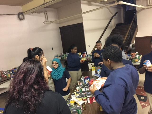 Students sorting through canned goods for giving project